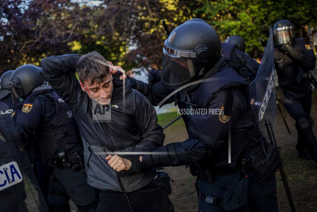 Bernat Armangue Spanish police detain a left-wing protester in Madrid's Vallecas neighborhood, Spain, Wednesday, April 7, 2021. Spanish police have used batons to keep protesters away from a campaign event of the far-right Vox party in Madrid. Scuffles started Wednesday when Santiago Abascal, the national leader of Vox, approached a crowd gathered to protest the party rally in Madrid's Vallecas neighborhood, a traditional left-wing bastion. Riot peace charged the bunches of protesters to keep them away from the party campaign event for upcoming regional elections. (AP Photo/Bernat Armangue)