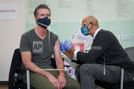 California Gov. Gavin Newsom, left, receives a Moderna COVID-19 vaccine booster shot from California Health and Human Services Secretary Dr. Mark Ghaly at Asian Health Services in Oakland, Calif., Wednesday, Oct. 27, 2021. (AP Photo/Jeff Chiu)