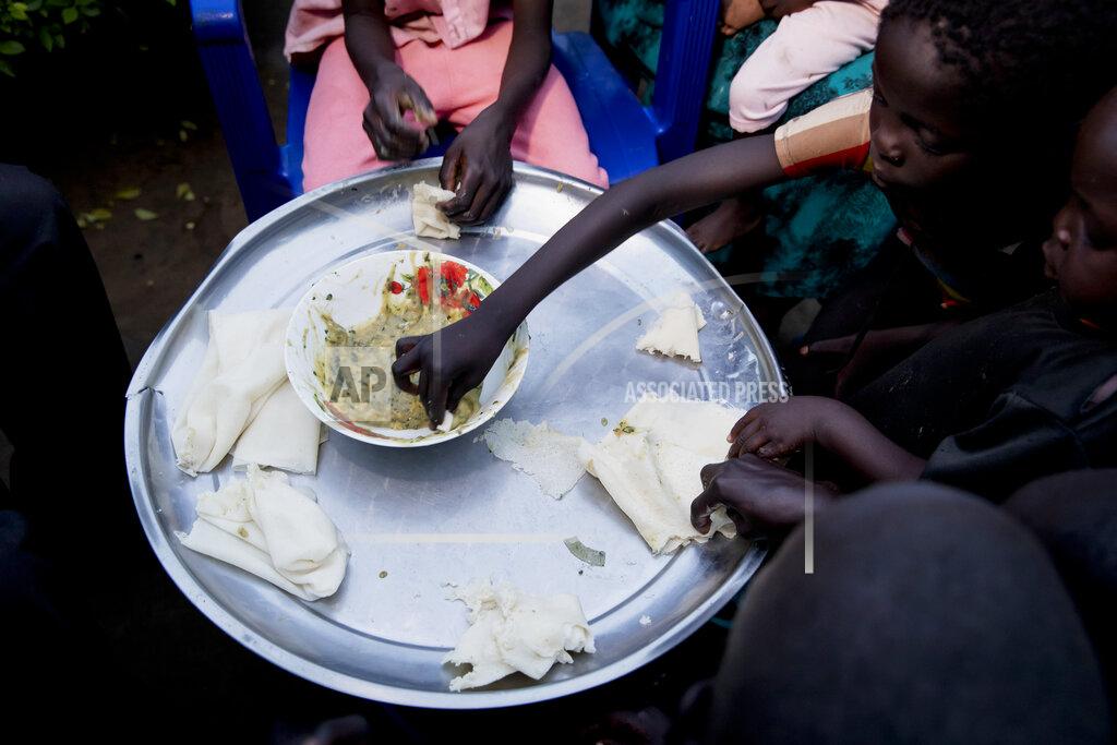 Adrienne Surprenant Paska Itwari Beda, the young mother of five children, shares a meal with her family at her Juba, South Sudan home, Thursday, May 27, 2021. The young mother of five children - all of them under age 10 - sometimes survives on one bowl of porridge a day, and her entire family is lucky to scrape together a single daily meal, even with much of the money Beda makes cleaning offices going toward food. (AP Photo/Adrienne Surprenant)