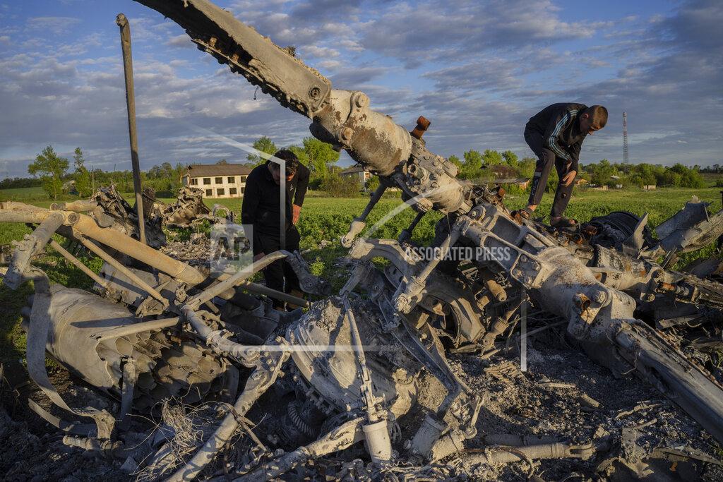 Bernat Armangue Oleksiy Polyakov, right, and Roman Voitko check the remains of a destroyed Russian helicopter lie in a field in the village of Malaya Rohan, Kharkiv region, Ukraine, Monday, May 16, 2022. (AP Photo/Bernat Armangue)