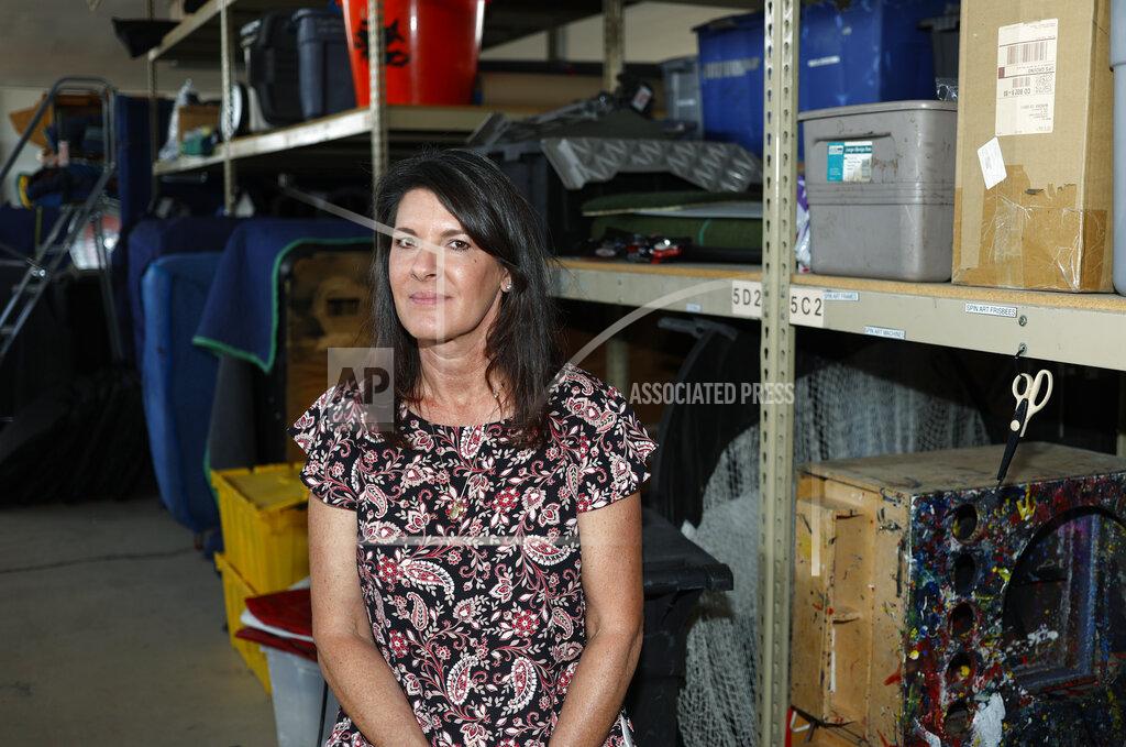 In this Friday, June 5, 2020 photo,, Dawn Abbott, chief executive officer of Fun Productions, a small corporate events company that she started in 1991, is shown amid the myriad unused items stacked in the company's northeast Denver warehouse. The woman's events business was hit hard by concellations with the spread of the new coronavirus and now, three months into the downturn, she does not foresee a quick rebound in the future of her enterprise. (AP Photo/David Zalubowski)