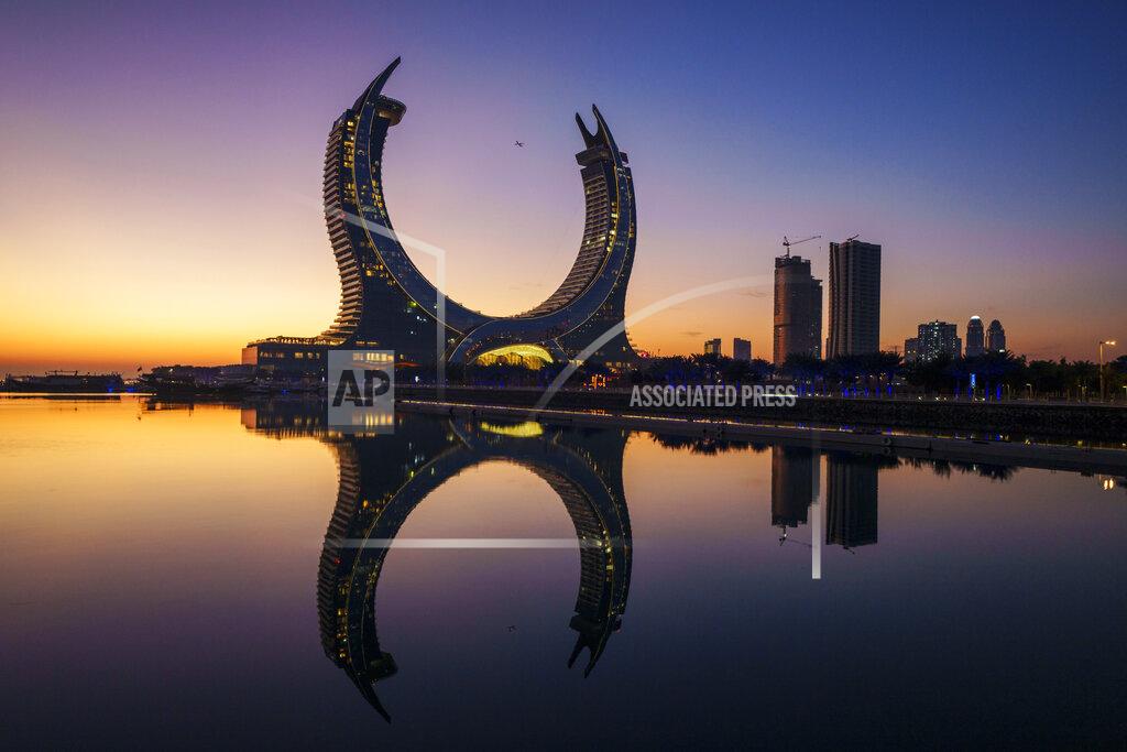 Pavel Golovkin A plane flies over the Crescent Tower Lusail during sunrise in Lusail, Qatar, Thursday, Nov. 24, 2022. (AP Photo/Pavel Golovkin)