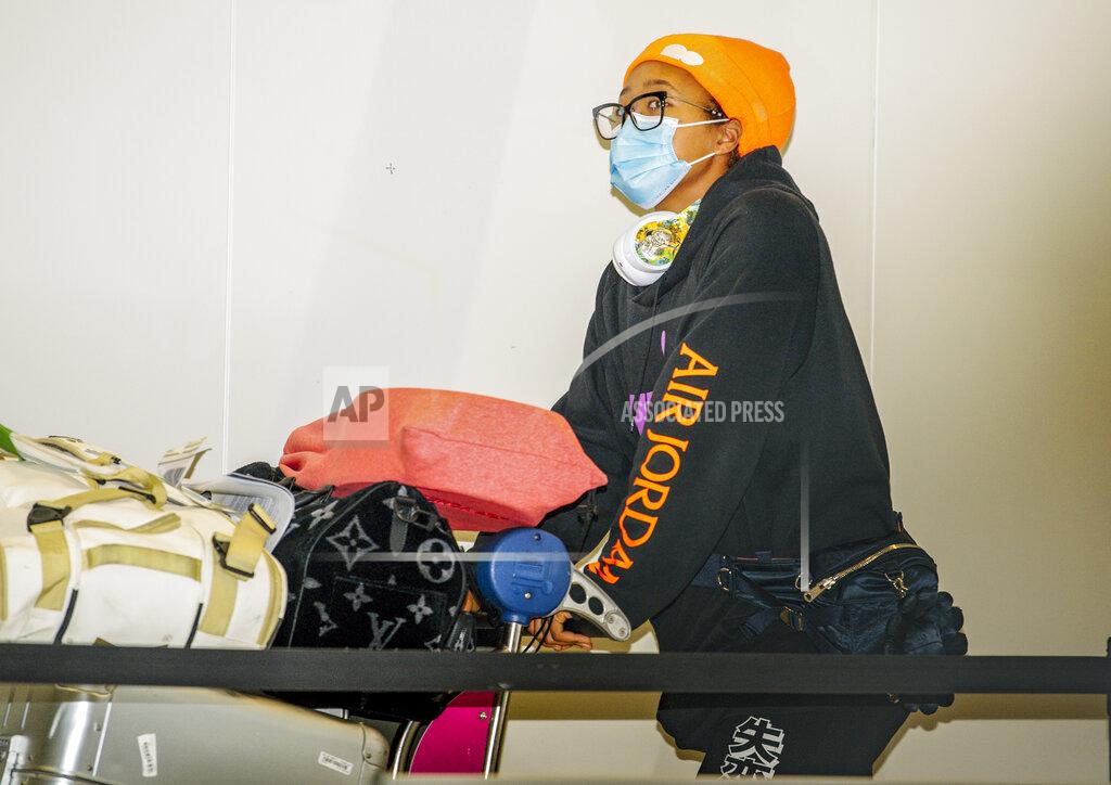 Morgan Sette Japan's Naomi Osaka arrives at Adelaide Airport ahead of the Australian Open tennis championship, Adelaide, Australia, Thursday, Jan. 14, 2021. Arriving players will serve a 14-day quarantine period ahead of the first Grand slam tennis tournament that is set to get underway on February 8 in Melbourne. (Morgan Sette/AAP Image via AP)