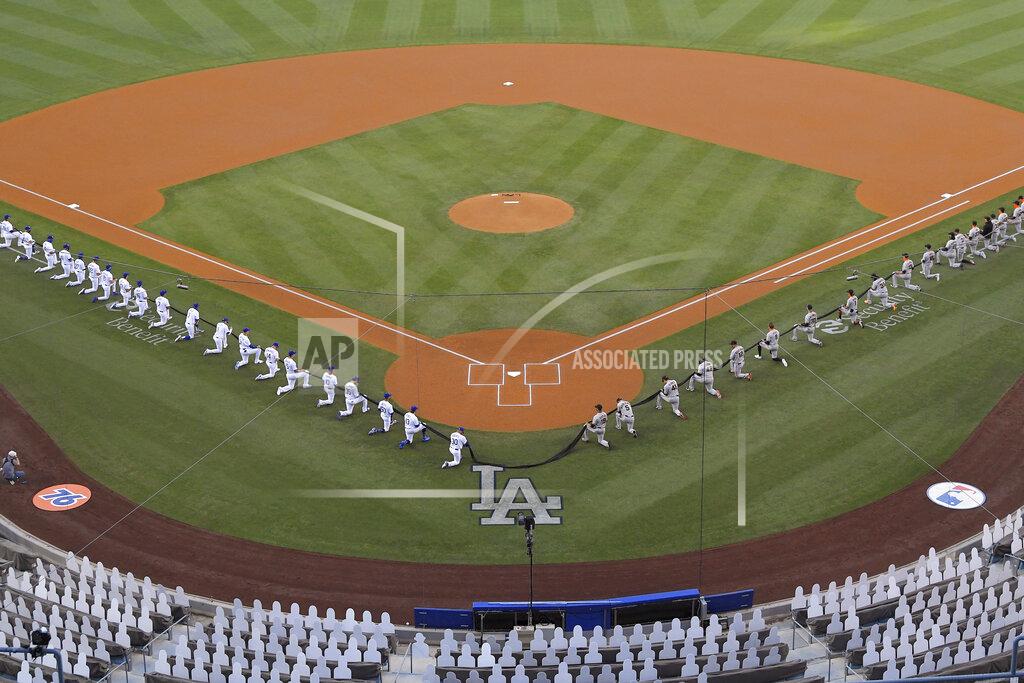 Mark J. Terrill Members of the Los Angeles Dodgers and the San Francisco Giants kneel during a moment of silence prior to an opening day baseball game Thursday, July 23, 2020, in Los Angeles. (AP Photo/Mark J. Terrill)