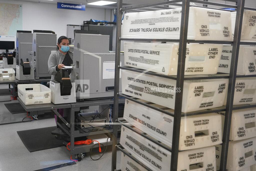 Wilfredo Lee A workers scans and tabulate ballots, Tuesday, Nov. 3, 2020, at the Miami-Dade County Elections Department in Doral, Fla. (AP Photo/Wilfredo Lee)