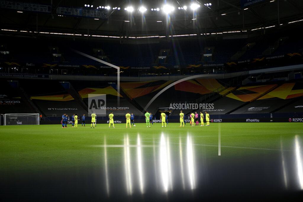 Ina Fassbender Players observe a moment of silence for the victims of the COVID-19 pandemic before the Europa League round of 16 soccer match between Inter Milan and Getafe at the Veltins-Arena in Gelsenkirchen, Germany, Wednesday, Aug. 5, 2020. (Ina Fassbender, Pool Photo via AP)