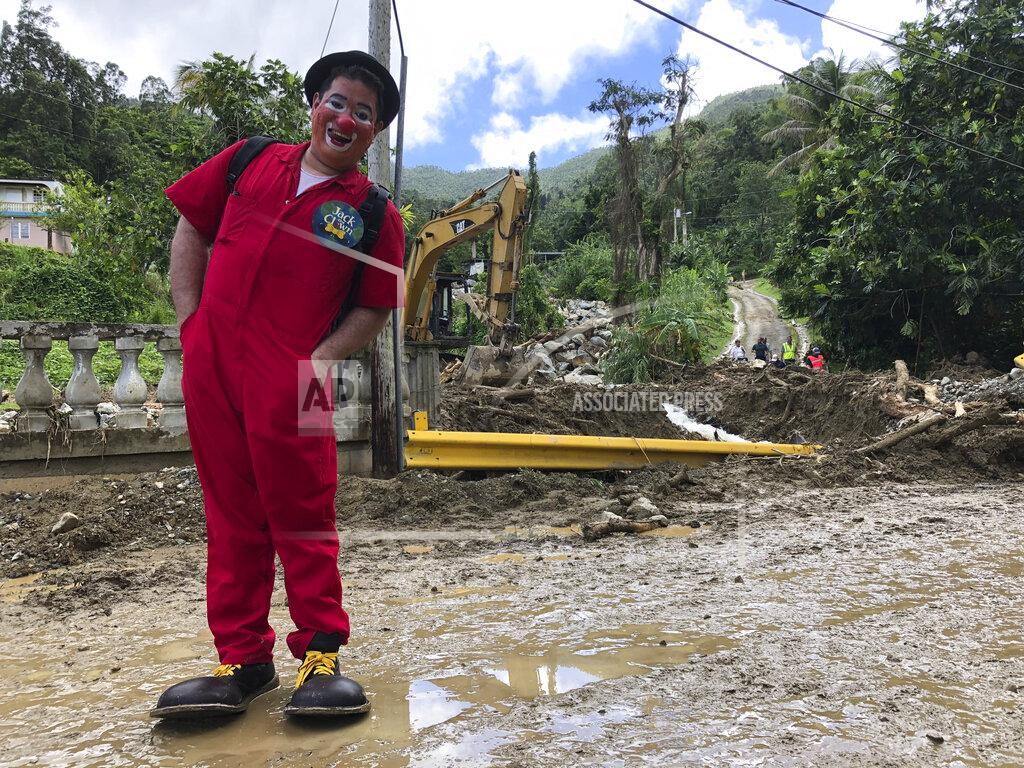 Danica Coto Danciel Rivera, who is known as the "Payaso Jack," poses for a portrait after he tried to cheer up children and adults as part of a church group who visited the area to help those affected by Hurricane Fiona in the rural community of San Salvador in Caguas, Puerto Rico, Thursday, Sept. 22, 2022. (AP Photo/Danica Coto)