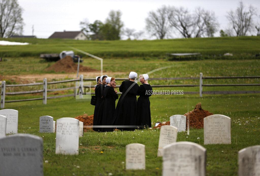 Jessie Wardarski In this Sunday, May 17, 2020, photo, a group of friends visit the grave of a fellow Old Order Stauffer Mennonite member in a cemetery next to the church in New Holland, Pa. The women were among dozens of other congregants who attended the church's first in-person service since the start of the coronavirus outbreak in March. (AP Photo/Jessie Wardarski)