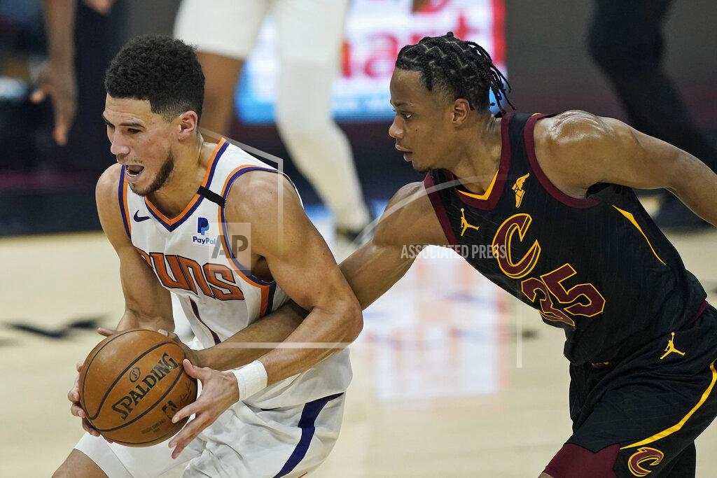 Tony Dejak Phoenix Suns' Devin Booker, left, drives past Cleveland Cavaliers' Isaac Okoro in the first half of an NBA basketball game, Tuesday, May 4, 2021, in Cleveland. (AP Photo/Tony Dejak)