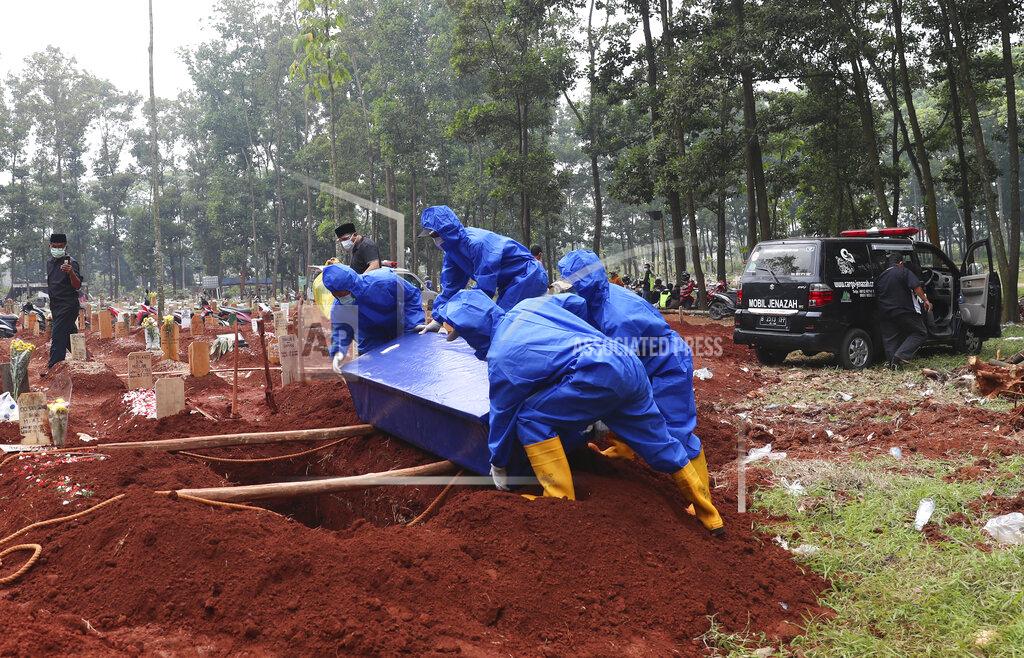 Achmad Ibrahim Workers in protective suits carry a coffin containing the body of a COVID-19 victim to a grave for a burial at Cipenjo cemetery in Bogor, West Java, Indonesia, Wednesday, July 14, 2021. (AP Photo/Achmad Ibrahim)