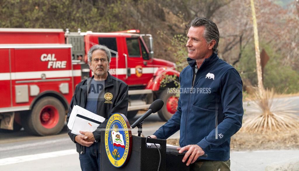 Ron Holman California Gov. Gavin Newsom speaks to the media Thursday, Sept. 23, 2021, in Sequoia National Park, Calif., before signing a climate package into law. State Assembly Member Richard Bloom, D-Santa Monica, listens on left. Newsom on Thursday approved nearly $1 billion in new spending to prevent wildfires, signaling a policy shift in a state that historically focused more on putting out fires than stopping them before they start. (Ron Holman/The Times-Delta via AP)