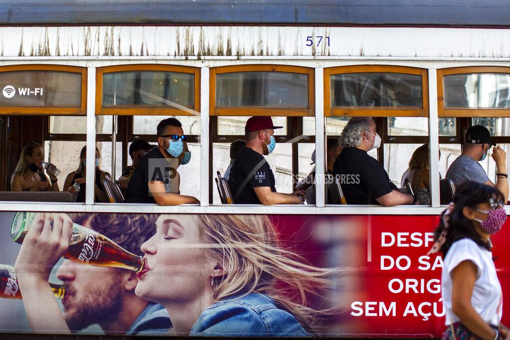 Manu Fernandez Passengers wear face masks for protection against the new coronavirus while riding on a tram in Lisbon, Portugal, Friday, Aug. 14, 2020. Portuguese health authorities have advised people to wear face masks when using public transport to help stem the spread of COVID-19. (AP Photo/Manu Fernandez)