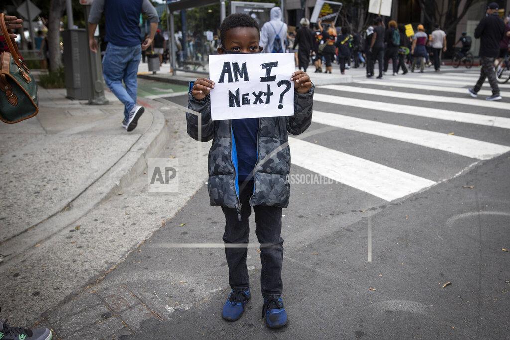 Christian Monterrosa A boy holds a sign during a protest in downtown Los Angeles, Friday, May 29, 2020, over the death of George Floyd, who died in police custody on Memorial Day in Minneapolis. (AP Photo/Christian Monterrosa)