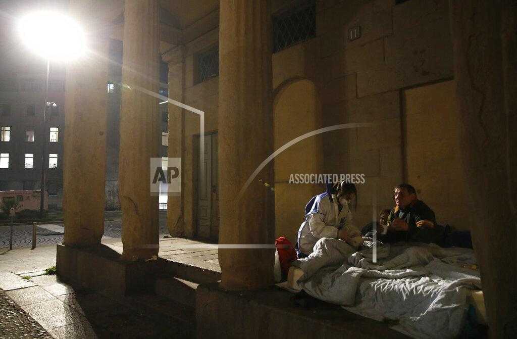 Antonio Calanni A volunteer nurse tends to homeless people on the streets of Milan, Italy, on Tuesday, March 24, 2020. (AP Photo/Antonio Calanni)