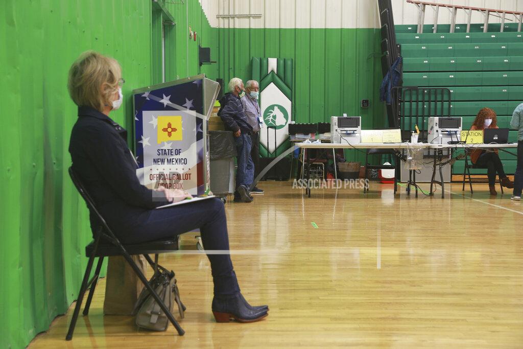 Cedar Attanasio A poll watcher sits in the Pojoaque Middle School gym voting center on Election Day, Tuesday, Nov. 3, 2020, in Pojoaque, N.M. (AP Photo/Cedar Attanasio)