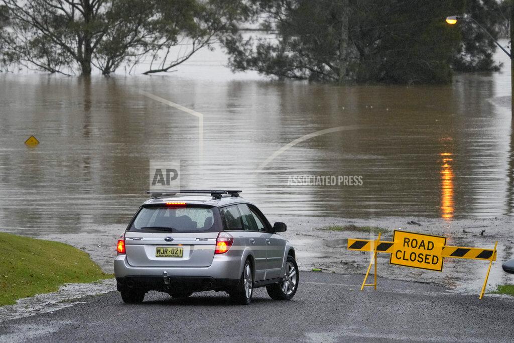 Mark Baker A car turns at a closed road in Richmond on the outskirts of Sydney, Australia, Monday, July 4, 2022. More than 30,000 residents of Sydney and its surrounds have been told to evacuate or prepare to abandon their homes on Monday as Australia's largest city braces for what could be its worst flooding in 18 months. (AP Photo/Mark Baker)