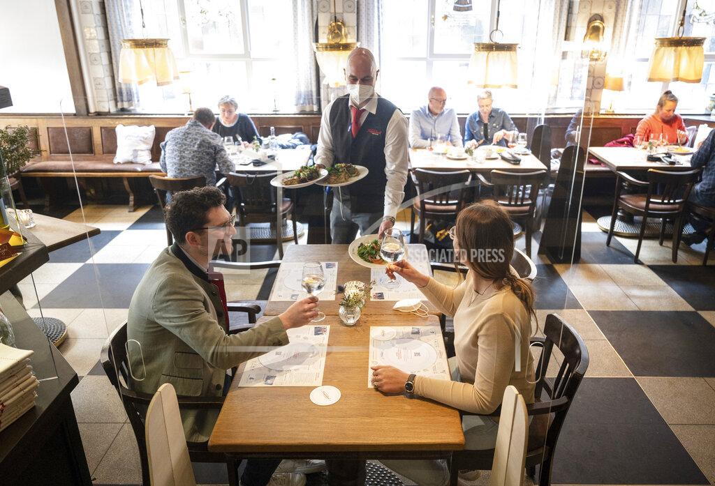 Bernd Thissen Linus and Regina are served lunch at the Grosser Kiepenkerl in Muenster, Germany, as restaurants are allowed to open due to the city's low corona infections rate on Friday, May 21, 2021. (Bernd Thissen/dpa via AP)