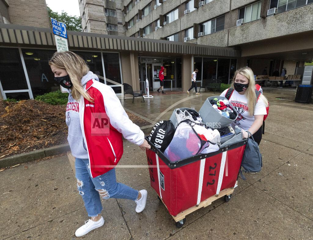 Freshmen Lauren Tamborini and Bailey Donahue move out of Sellery Residence Hall Thursday, Sept. 10, 2020, the University of Wisconsin in Madison, Wis. The students plan on attending class online. Citing rapidly rising COVID-19 cases including two straight days in which one in five student tests came back positive, University of Wisconsin-Madison Chancellor Rebecca Blank locked down the state's largest university campus for two weeks. (Mark Hoffmann/Milwaukee Journal-Sentinel via AP)