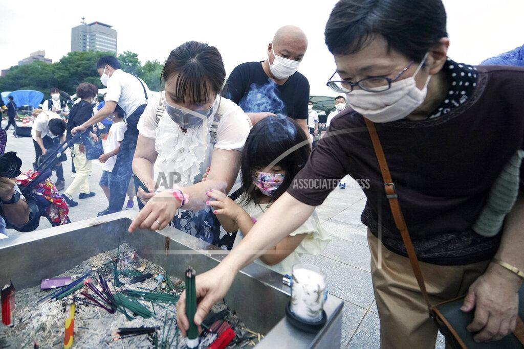 Eugene Hoshiko People burn joss sticks in front of the cenotaph for the atomic bombing victims before the start of a ceremony to mark the 75th anniversary of the U.S. bombing in Hiroshima, western Japan, early Thursday, Aug. 6, 2020. (AP Photo/Eugene Hoshiko)