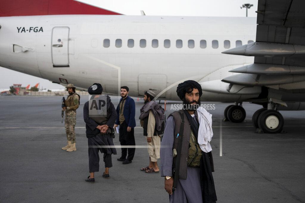 Bernat Armangue Taliban personnel stand beside a plane at the airport in Kabul, Afghanistan, Thursday, Sept. 9, 2021. Some 200 foreigners, including Americans, flew out of Afghanistan on an international commercial flight from Kabul airport on Thursday, the first such large-scale departure since U.S and foreign forces concluded their frantic withdrawal at the end of last month. (AP Photo/Bernat Armangue)