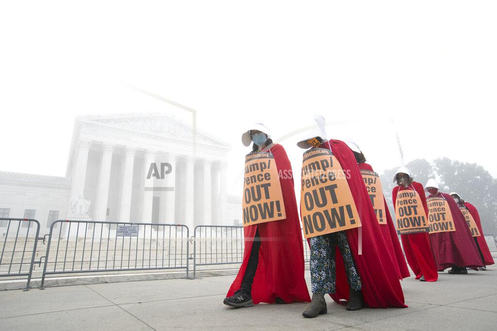 Jose Luis Magana Activists opposed to the confirmation of President Donald Trump's Supreme Court nominee, Judge Amy Coney Barrett, dressed as characters from "The Handmaid's Tale," protest at the Supreme Court on a foggy day, Thursday, Oct. 22, 2020 in Washington. (AP Photo/Jose Luis Magana)