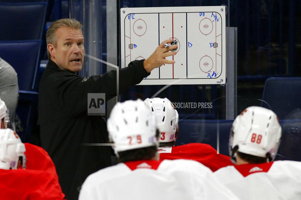 Calgary Flames associate coach Geoff Ward gives instruction during an NHL hockey practice Tuesday, Nov. 26, 2019, in Buffalo, N.Y. Flames general manager Brad Treliving says coach Bill Peters remains on the staff but wasn’t certain whether he’d be behind the bench for the next game. The team and the NHL are both investigating an allegation the Peters directed racial slurs at a player 10 years ago when the two were in the minors. Akim Aliu, a Nigerian-born player, says Peters “dropped the N bomb several times” in a dressing room during his rookie year. (AP Photo/Jeffrey T. Barnes)
