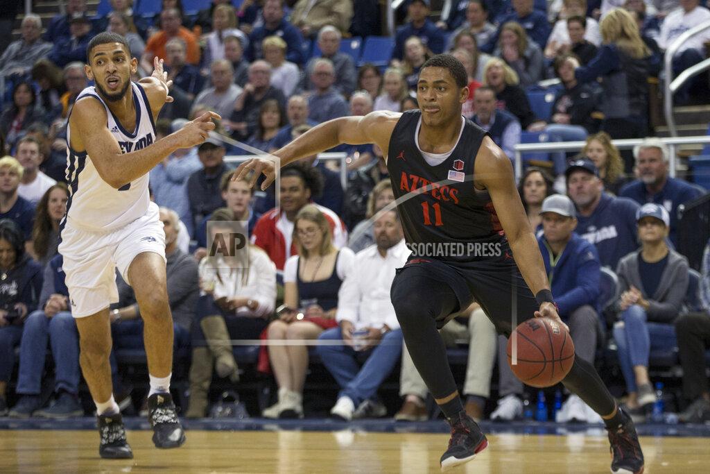 Tom R. Smedes San Diego State forward Matt Mitchell (11) drives past Nevada forward Robby Robinson (1) during the first half of an NCAA college basketball game in Reno, Nev., Saturday, Feb. 29, 2020. (AP Photo/Tom R. Smedes)