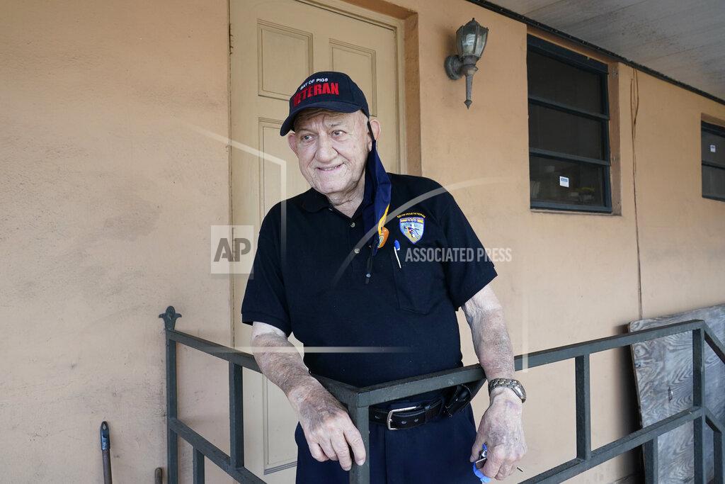 Wilfredo Lee Bay of Pigs veteran Rigoberto Montesinos, 82, poses for a photo, Tuesday, Feb. 9, 2021, at his home in Hialeah, Fla. Montesinos was frustrated his first vaccine appointment was inexplicably cancelled, but he finally got his first dose Monday. Montesinos said he worried about side effects, but "at my age, and with the virus spiking, I can't be putting myself at risk." (AP Photo/Wilfredo Lee)