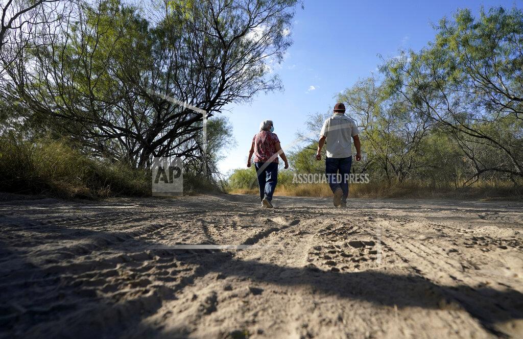 Pamela Rivas, left, with her son Michael Maldonado, right, walks on her property that runs along the Rio Grande in Los Ebanos, Texas, Friday, Nov. 20, 2020. The U.S. government has been trying to take Pamela Rivas' land for a border wall since before Joe Biden was vice president. (AP Photo/Eric Gay)