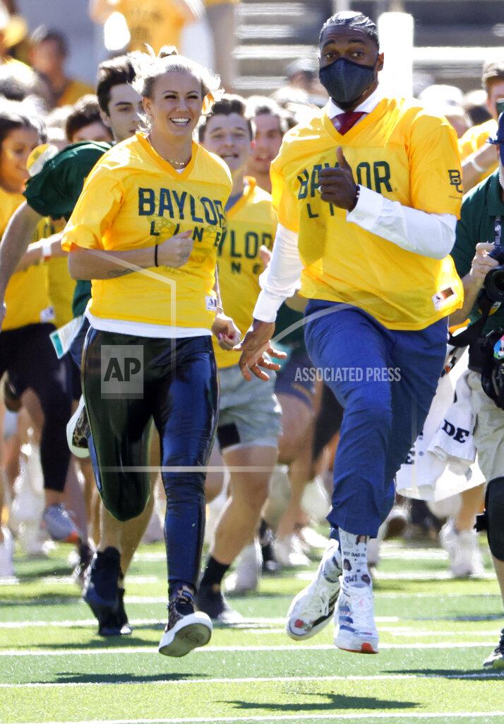 Ron Jenkins NFL football and former Baylor quarterback Robert Griffin III, right, runs onto the field with fans before Baylor played BYU in an NCAA college football game, Saturday, Oct. 16, 2021, in Waco, Texas. (AP Photo/Ron Jenkins)