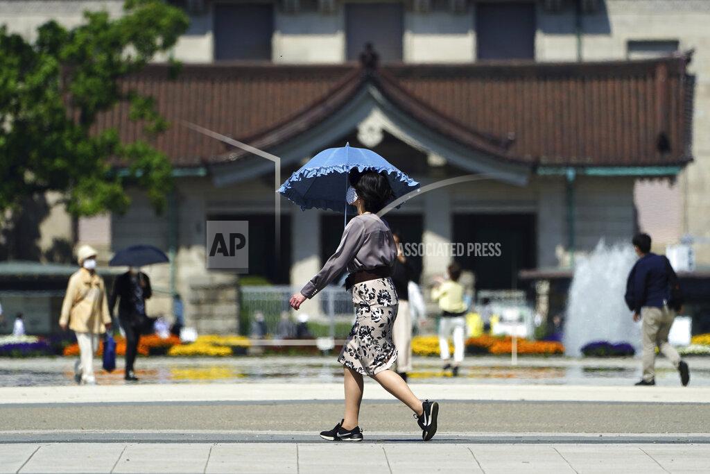 Eugene Hoshiko A woman wearing a protective mask to help curb the spread of the coronavirus walks at a park Wednesday, April 21, 2021, in Tokyo. The Japanese capital confirmed more than 840 new coronavirus cases on Wednesday. (AP Photo/Eugene Hoshiko)