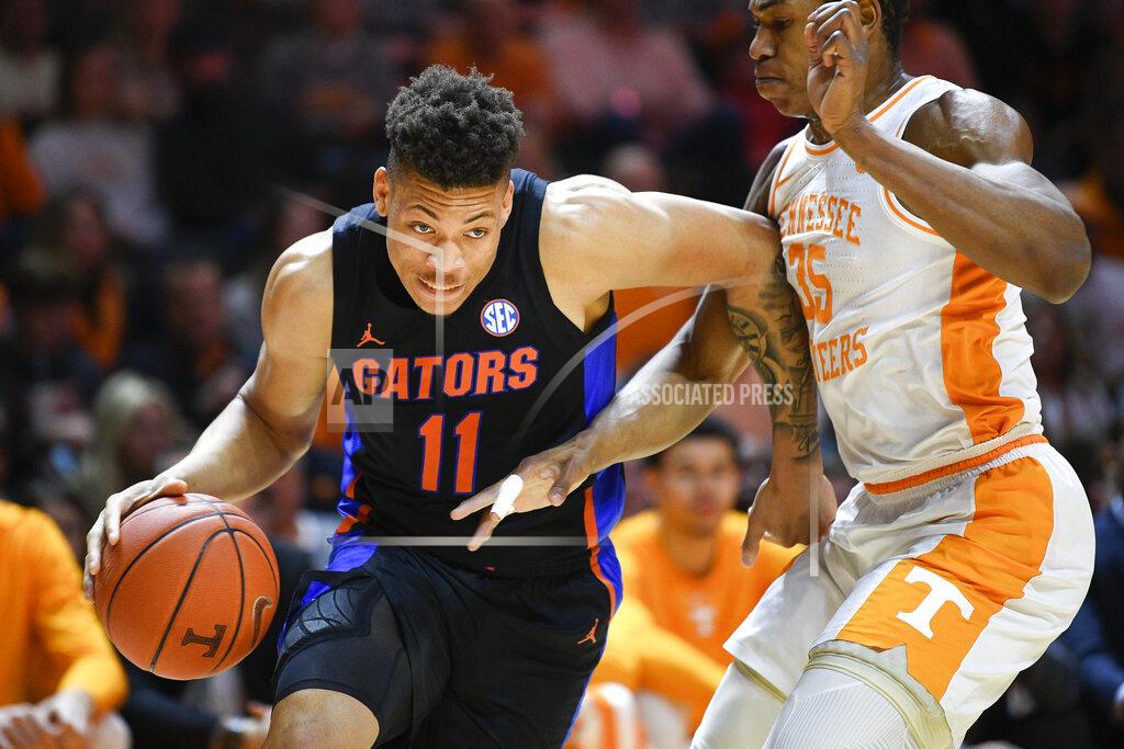 FILE - Florida forward Keyontae Johnson (11) dribbles around Tennessee guard/forward Yves Pons (35) during an NCAA college basketball game in Knoxville, Tenn., on Saturday, Feb. 29, 2020. University of Florida basketball player Keyontae Johnson, who collapsed during a game last December, is deciding whether he wants to try to play professionally or cash in a $5 million insurance policy. Two people with knowledge of Keyontae Johnson’s situation told The Associated Press that the senior forward's policy went into effect in July 2020, five months before he crashed face-first onto the court at Florida State. Both people spoke to the AP on condition of anonymity because of privacy concerns. (Calvin Mattheis/Knoxville News Sentinel via AP, File)