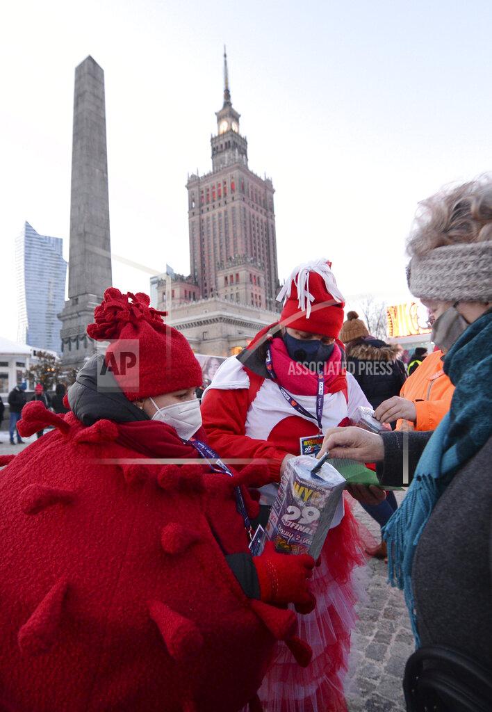 Czarek Sokolowski A child in a red costume collects money for Poland's most popular nationwide fundraiser for health purposes, the Great Orchestra of Christmas Charity, that was postponed by two weeks due to the pandemic, in downtown Warsaw, Poland, on Sunday, Jan. 31, 2021. Anti-government protesters angry about a near-total abortion ban suspended their marches for the weekend to show solidarity and ensure that they didn't steal the spotlight from the event. (AP Photo/Czarek Sokolowski)