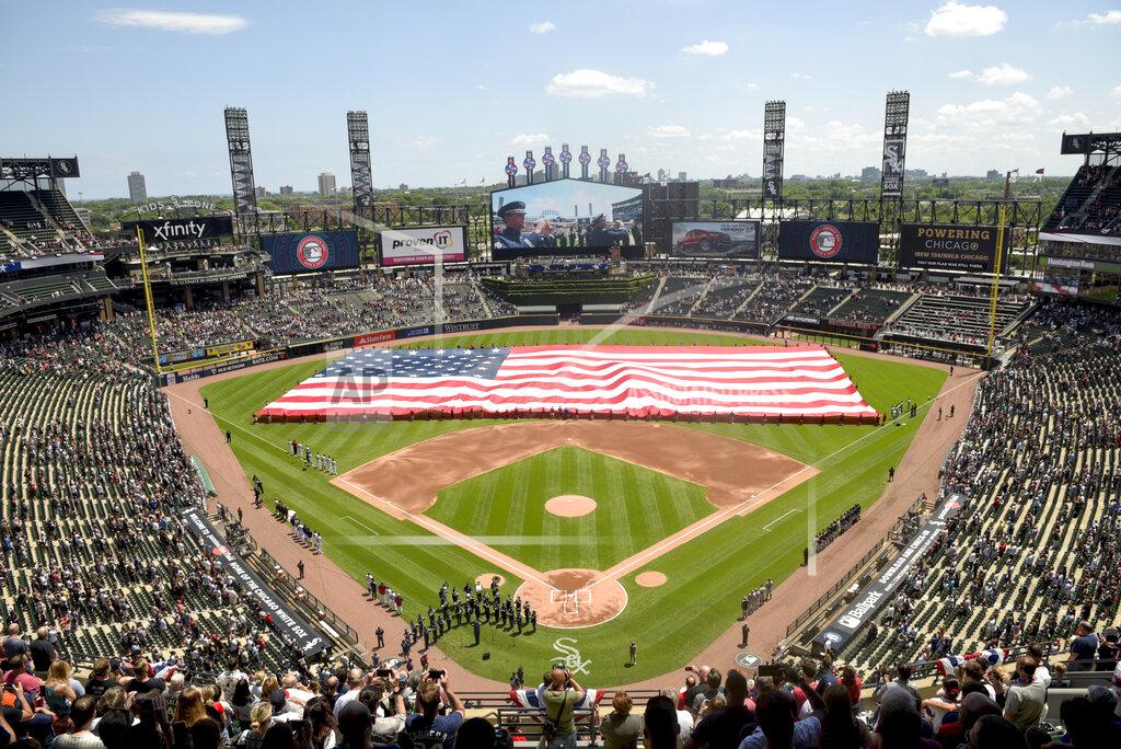 Mark Black FILE - In this July 4, 2019, file photo, an American Flag is unfurled in the outfield during the playing of the National Anthem before the start a baseball game between the Chicago White Sox and the Detroit Tigers in Chicago. Major League Baseball owners gave the go-ahead Monday, May 11, 2020, to making a proposal to the players’ union that could lead to the coronavirus-delayed season starting around the Fourth of July weekend in ballparks without fans, a plan that envisioned expanding the designated hitter to the National League for 2020. (AP Photo/Mark Black, File)