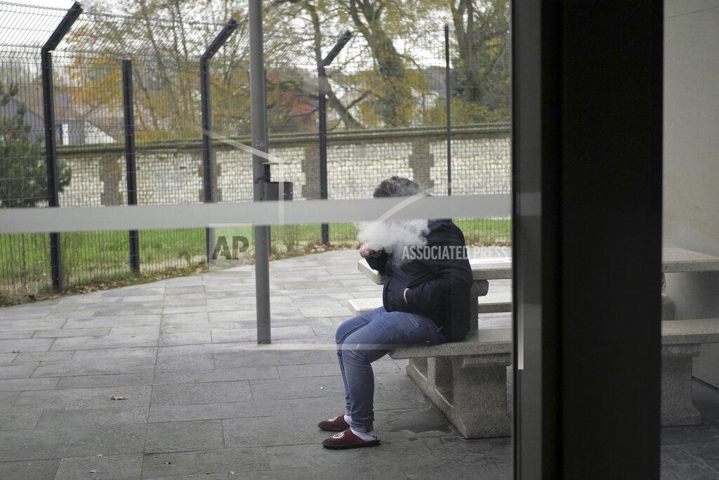 Thibault Camus A patient smokes an electronic cigarette in the Rouvray psychiatric hospital, in Rouen, western France, Wednesday, Nov. 25, 2020. Lockdowns that France has used to fight the coronavirus have come at considerable cost to mental health. Surveying points to a surge of depression most acute among people without work, in financial hardship and young adults. (AP Photo/Thibault Camus)