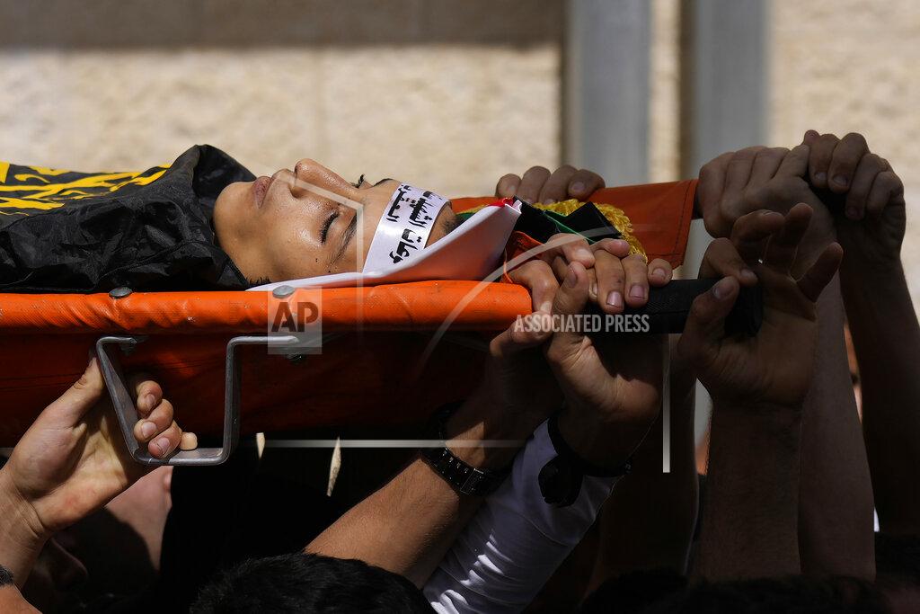 Majdi Mohammed Palestinian mourners carry the body of Amjad al-Fayyed, 17, during his funeral in the West Bank refugee camp of Jenin, Saturday, May 21, 2022. Israeli troops shot and killed al-Fayyed as fighting erupted when soldiers entered a volatile town in the occupied West Bank early Saturday, the Palestinian health ministry and local media said. (AP Photo/Majdi Mohammed)