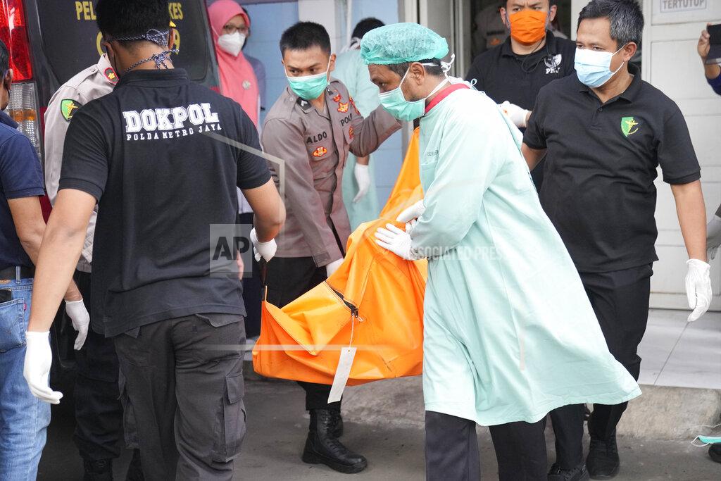 Dita Alangkara Officers load a body bag containing the body of a victim of a prison fire to be transferred to the national police hospital for identification from the local hospital in Tangerang on the outskirts of Jakarta, Indonesia, Wednesday, Sept. 8, 2021. A massive fire raged through the overcrowded prison early Wednesday, killing a number of inmates. (AP Photo/Dita Alangkara)