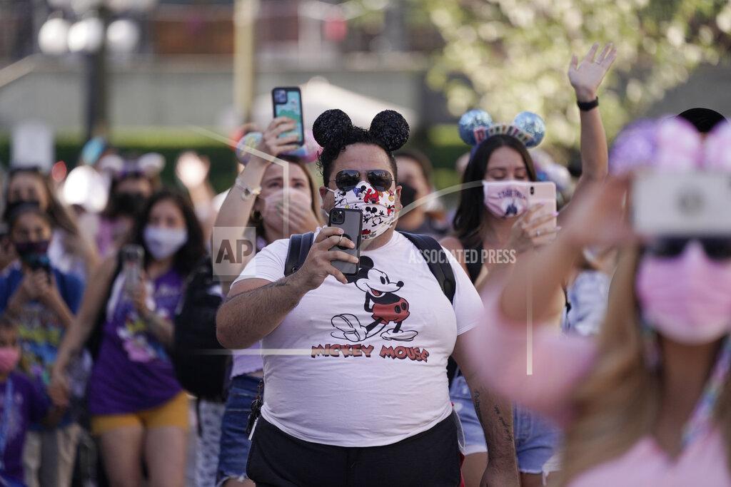 Jae Hong Guests walk down Main Street USA at Disneyland in Anaheim, Calif., Friday, April 30, 2021. The iconic theme park in Southern California that was closed under the state's strict virus rules swung open its gates Friday and some visitors came in cheering and screaming with happiness.(AP Photo/Jae Hong)