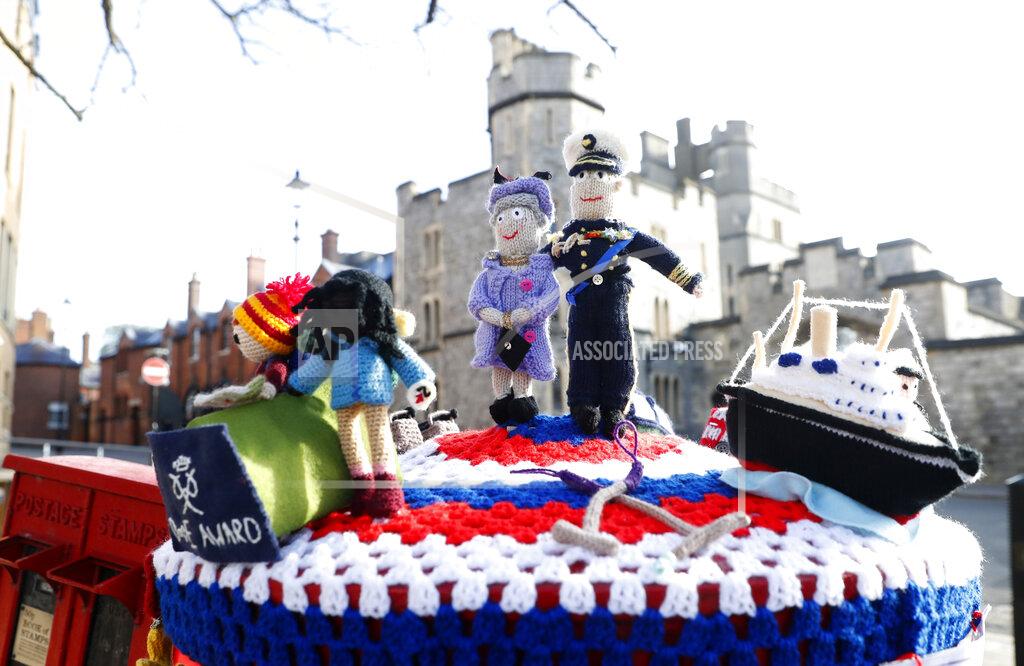 Alastair Grant A knitted top cover for a post box depicting Britain's Queen Elizabeth II and her husband Prince Philip in Windsor, England, Friday, April 16, 2021. Prince Philip husband of Britain's Queen Elizabeth II died April 9, aged 99, his funeral will take place Saturday at Windsor Castle in St George's Chapel. The knitted top show some of Prince Philips favorites: the Royal Yacht Britannia, right, the Duke of Edinburgh award scheme for young people and his hobby of carriage driving . (AP Photo/Alastair Grant)