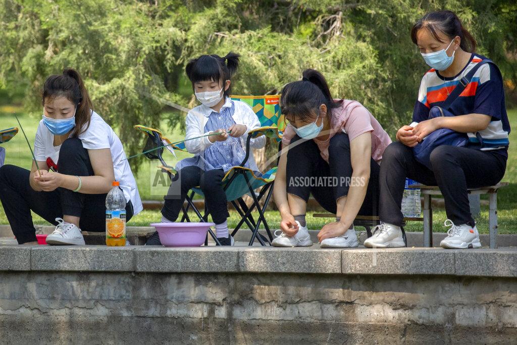 Mark Schiefelbein People wear face masks to help protect themselves against the new coronavirus as they fish in a pond at a public park in Beijing, Saturday, May 2, 2020. China, where the pandemic began in December, reported one new infection and no deaths in the 24 hours through midnight Friday. (AP Photo/Mark Schiefelbein)