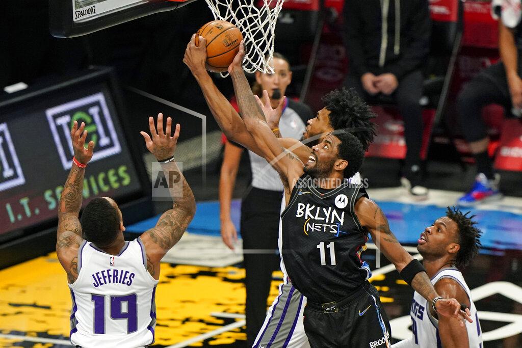 Kathy Willens Sacramento Kings forward Marvin Bagley III tries to steal the ball from Brooklyn Nets guard Kyrie Irving (11) during the first half of an NBA basketball game, Tuesday, Feb. 23, 2021, in New York, as Sacramento Kings guards DaQuan Jeffries (19) and Buddy Hield (24) watch from the floor. (AP Photo/Kathy Willens)
