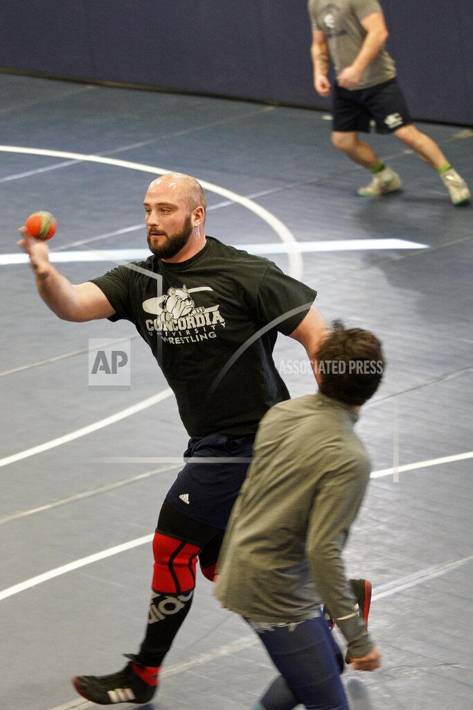 Nati Harnik In this March 2, 2020, photo, former Nebraska football player Tanner Farmer and current wrestler for Concordia University participates in a pre-practice game of "Spikeball," a cross between volleyball and the playground game "four square," in Seward, Neb. (AP Photo/Nati Harnik)