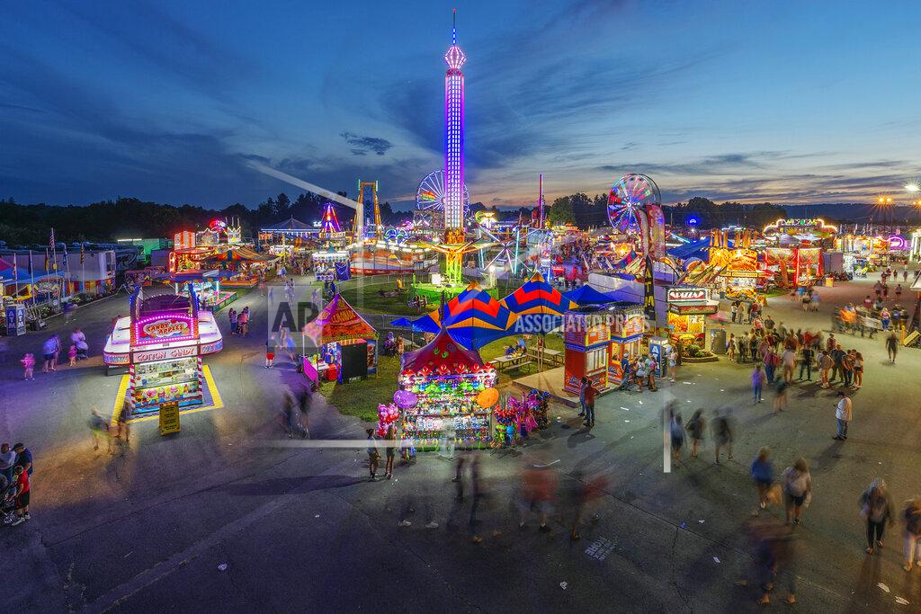 Craig Hudson FILE - In this Aug. 9, 2018, file photo, fair-goers attend The State Fair of West Virginia at the State Fairgrounds in Fairlea, W.Va. The State Fair of West Virginia has been canceled due to a coronavirus outbreak in the county where the event was set to take place. The fair’s board of directors, which last week had voted to move ahead with the event, said Thursday, June 18, 2020 that an unfolding virus flareup linked to a church in Greenbrier County has caused them to scrap the festival for the first time since World War II. (Craig Hudson/Charleston Gazette-Mail via AP, File)