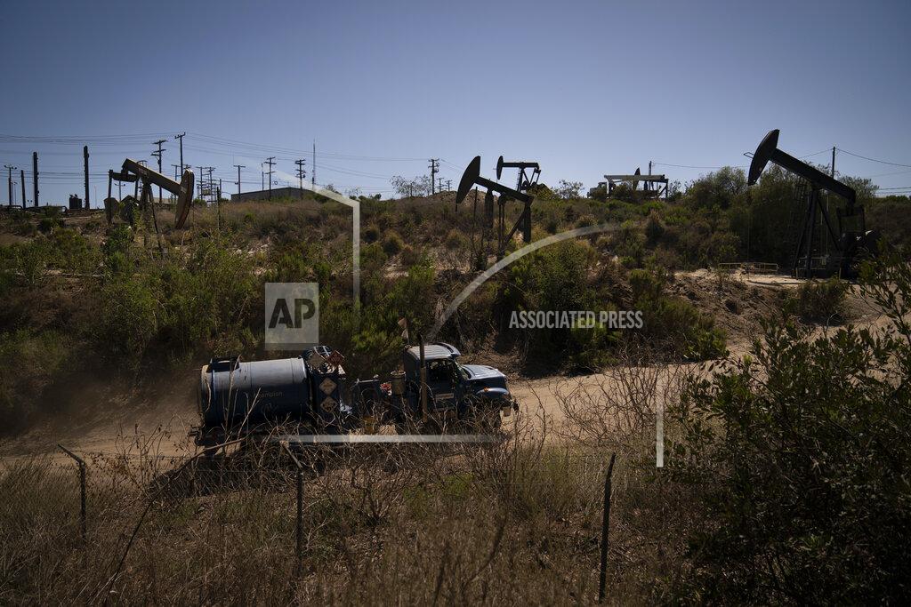 Jae C. Hong A truck drives past pump jacks operating at the Inglewood Oil Field, Thursday, June 10, 2021, in Los Angeles. (AP Photo/Jae C. Hong)