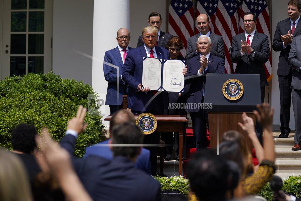 Evan Vucci FILE - In this June 5, 2020 file photo, President Donald Trump poses for a photo after signing the Paycheck Protection Program Flexibility Act during a news conference in the Rose Garden of the White House in Washington. Small businesses are in limbo again as the coronavirus outbreak rages and the government’s $659 billion relief program draws to a close. Companies still struggling with sharply reduced revenue are wondering if Congress will give them a second chance at the Paycheck Protection Program, which ends Friday, Aug. 7, after giving out 5.1 million loans worth $523 billion. (AP Photo/Evan Vucci, File)