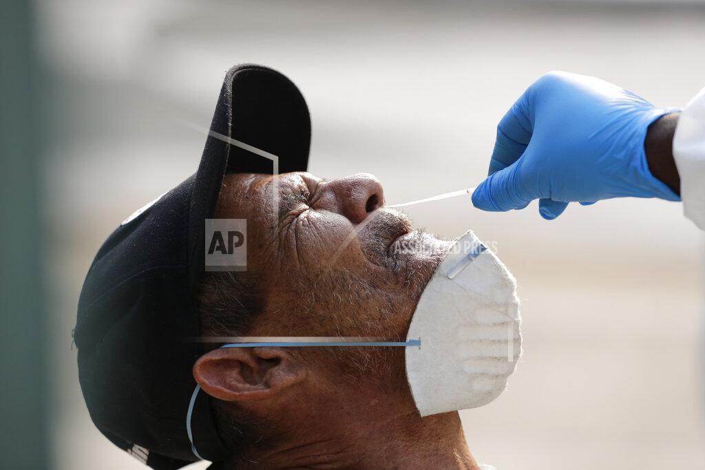 Lynne Sladky FILE - In this April 16, 2020. file photo, Leandro Moya Lara, who is homeless, is tested for COVID-19 in a program administered by the Miami-Dade County Homeless Trust, during the new coronavirus pandemic, in Miami. The Homeless Trust is targeting the senior population for testing, and is offering housing to those who test positive. (AP Photo/Lynne Sladky, File)