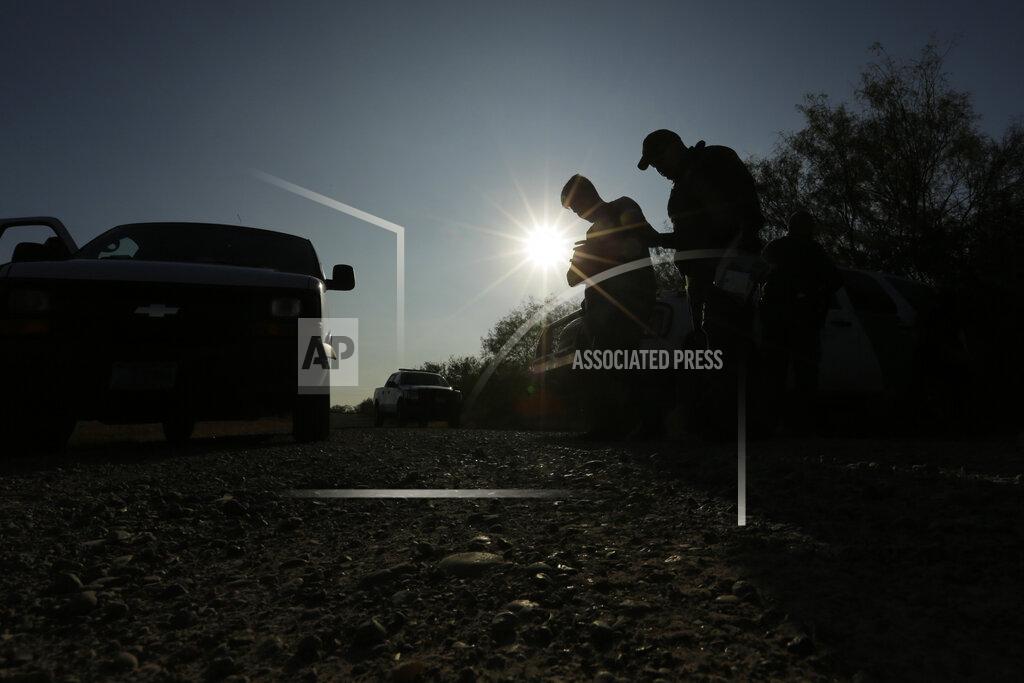 FILE - In this Nov. 6, 2019, file photo, Border Patrol agents stop men thought to have entered the country illegally, near McAllen, Texas, along the U.S.-Mexico border. President Joe Biden rushed to send the most ambitious overhaul of the nation's immigration system in a generation to Congress and signed nine executive actions to wipe out some of his predecessor's toughest measures to fortify the U.S.-Mexico border. But a federal court in Texas suspended his 100-day moratorium on deportations. (AP Photo/Eric Gay, File)