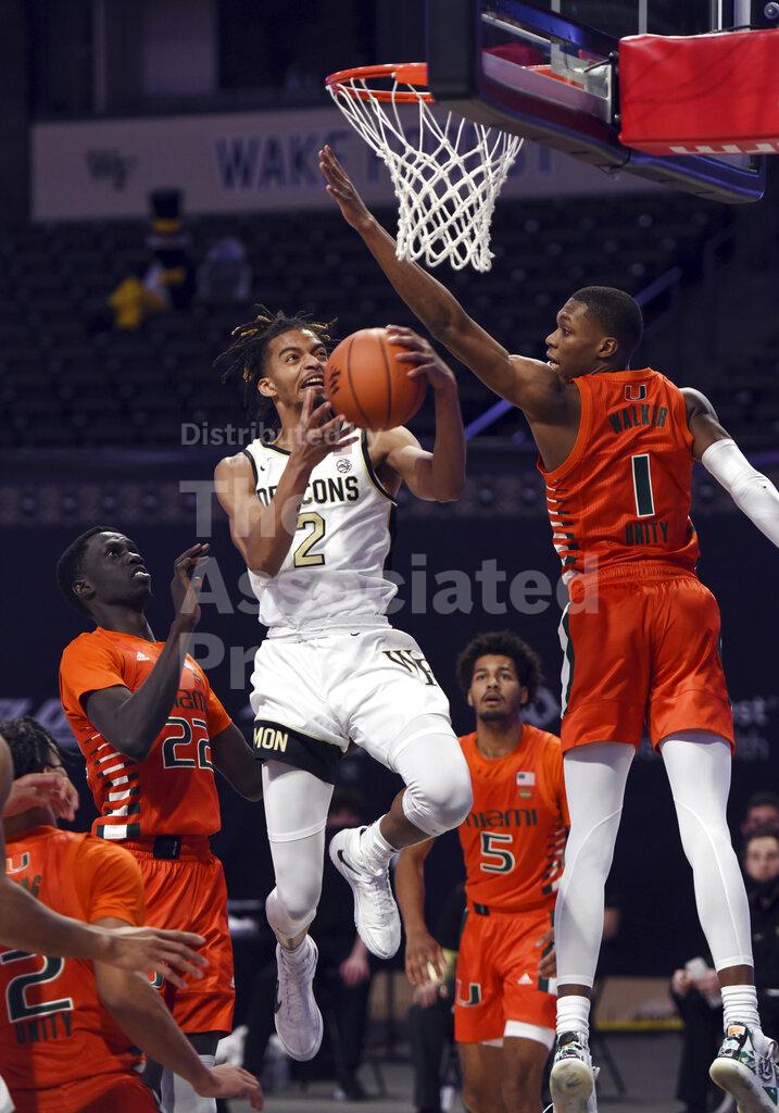 Wake Forest's Jalen Johnson sinks a lay up as he drives to the basket between Miami's Deng Gak (22) and Anthony Walker (1) during an NCAA college basketball game, Saturday, Jan. 30, 2021, at Joel Coliseum in Winston-Salem, N.C. (Walt Unks/The Winston-Salem Journal via AP)