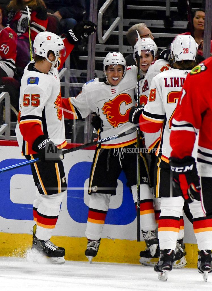 Matt Marton Calgary Flames left wing Johnny Gaudreau, second from left, celebrates with teammates after scoring a goal past Chicago Blackhawks goaltender Collin Delia during the first period of an NHL hockey game on Monday Jan. 7, 2019, in Chicago. (AP Photo/Matt Marton)