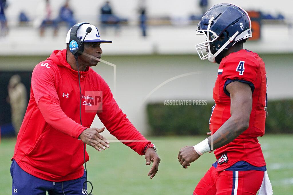 Rogelio V. Solis Jackson State football coach Deion Sanders, left, congratulates quarterback Jalon Jones (4) after guiding the team to a touchdown against Edward Waters during the first half of an NCAA college football in Jackson, Miss., Sunday, Feb. 21, 2021. The game marked the head coaching debut of Sanders. (AP Photo/Rogelio V. Solis)